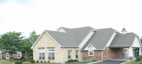 Single-story senior living facility with brick and stone exterior and a paved driveway.