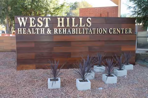 Exterior sign for West Hills Health & Rehabilitation Center with decorative pots.