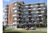 Exterior view of Evenglow Lodge senior living facility with balconies and parked cars.