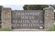 A large stone sign with brick pillars on each side displaying the text 'FRIENDSHIP HAVEN HEALTHCARE & REHABILITATION' outdoors with grass and trees in the background.
