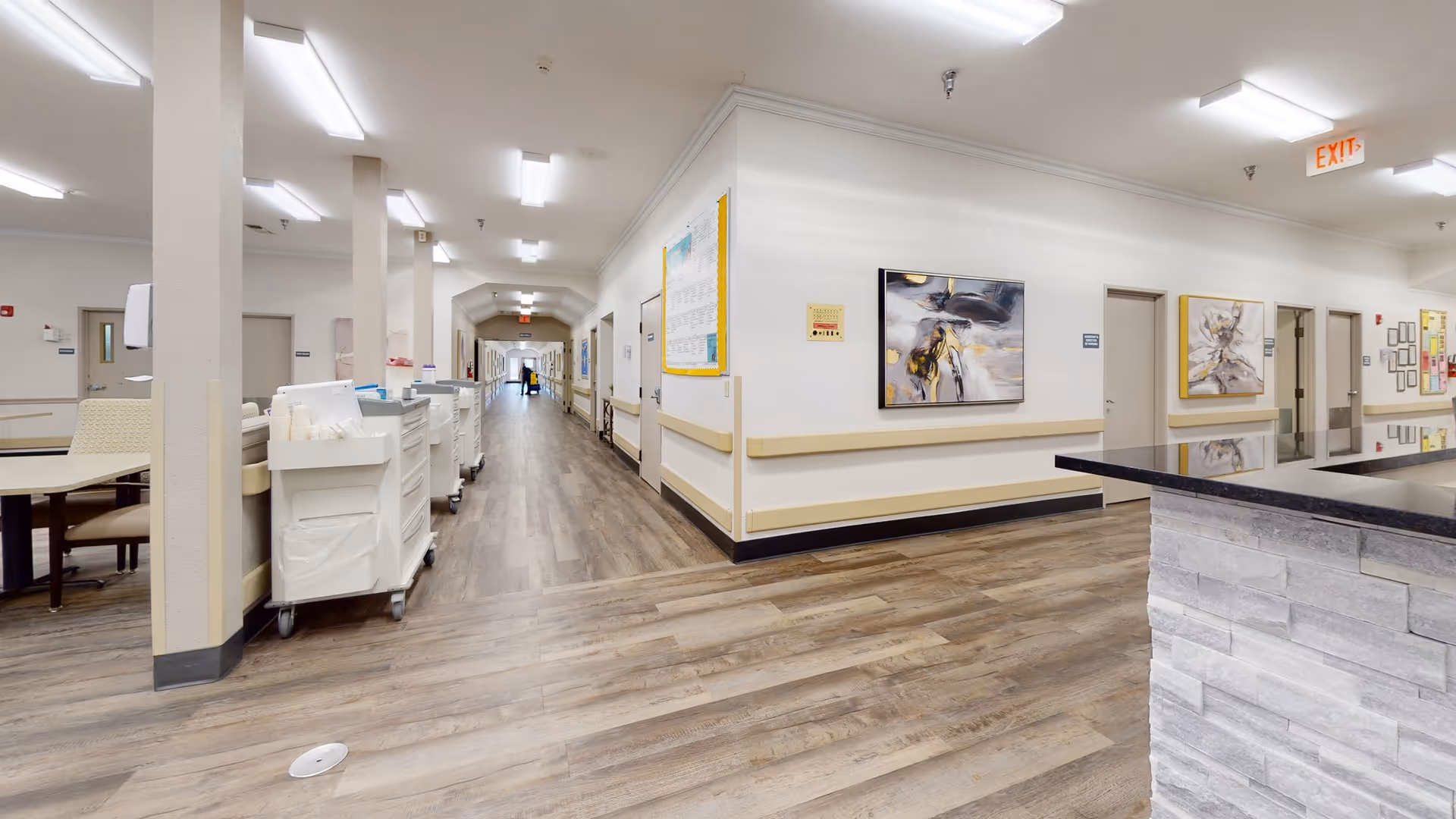 Interior view of a hallway in La Bahia Nursing & Rehabilitation facility with artwork on the walls.