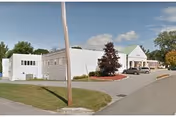 Exterior view of The Center For Nursing And Rehab with a driveway and parked car.