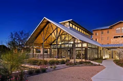 Exterior view of Querencia at Barton Creek with glass entrance and landscaped path.