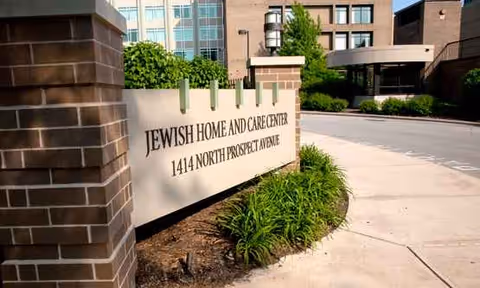 Exterior of Jewish Home and Care Center with entrance sign and landscaping
