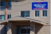 Exterior view of Hillcrest Village assisted living entrance with a blue sign.