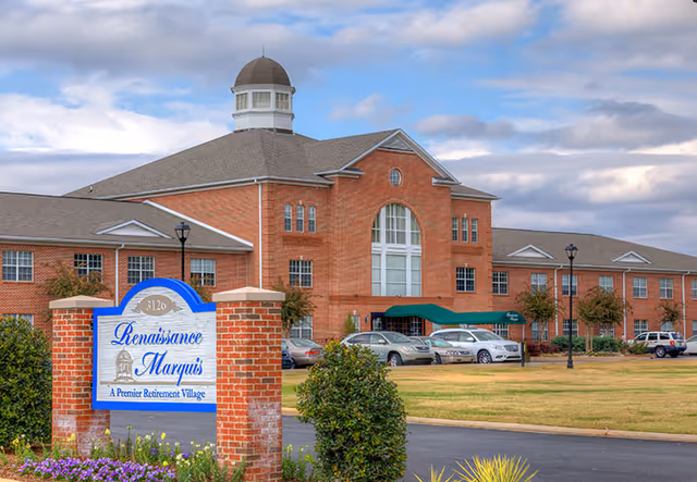 Brick multi-story senior living building with a green entrance canopy and a foreground sign reading "Renaissance Marquis."