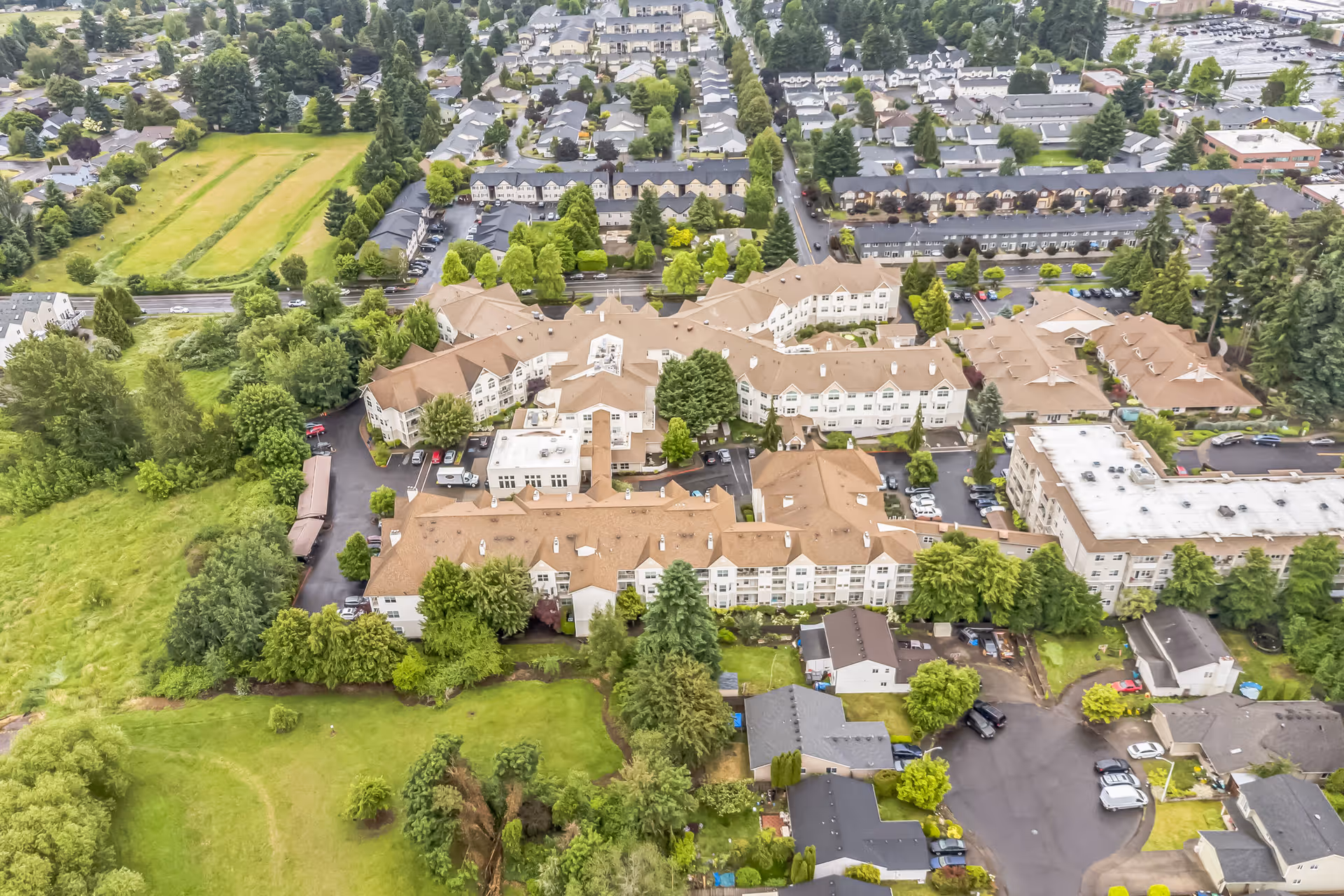 Aerial view of the Cogir of Glenwood Place senior living complex surrounded by trees and neighboring residential streets.