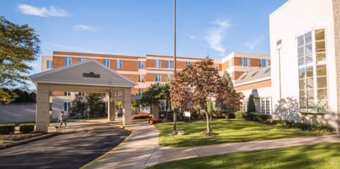 Exterior view of Presbyterian SeniorCare Westminster Place with a covered entrance and landscaped grounds.