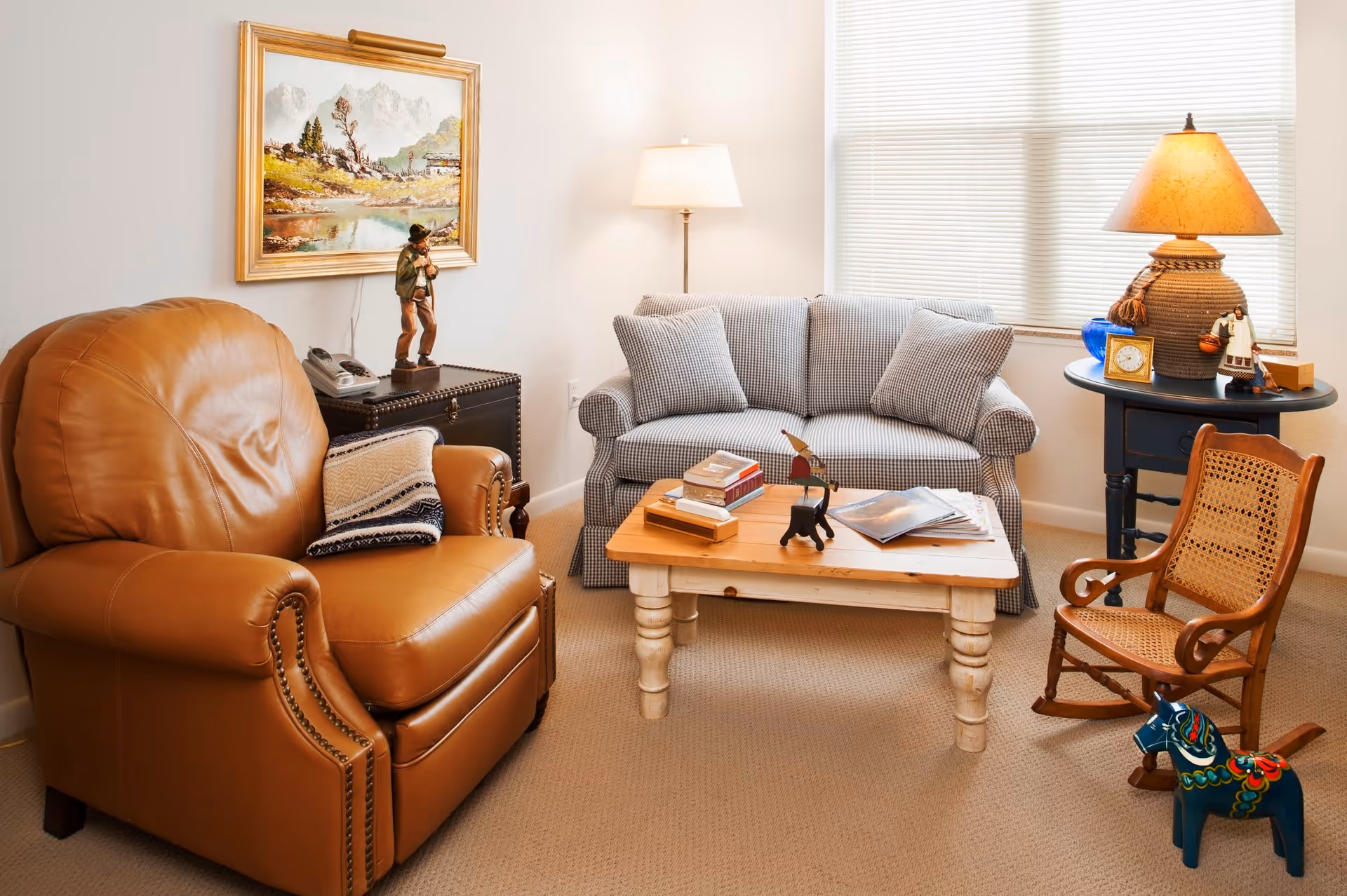 Cozy living room with a leather recliner, small upholstered sofa, wooden coffee table and lamps.