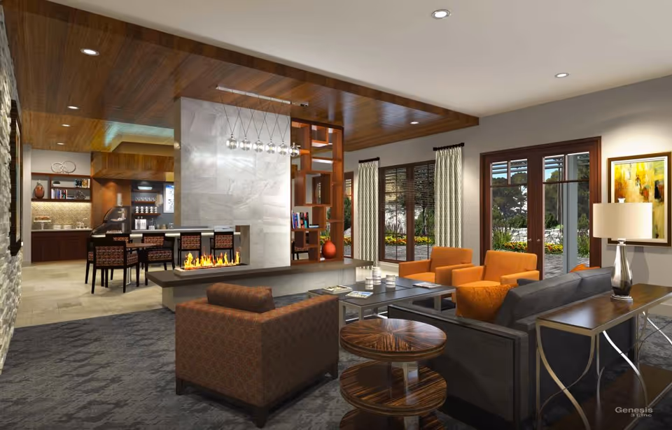 A modern senior living facility common area with comfortable seating including armchairs and sofas arranged around a low coffee table. There is a contemporary fireplace with a marble surround and a wooden ceiling above. Large windows and glass doors provide a view of a garden outside. The room is warmly lit with recessed ceiling lights and a table lamp, and there is a dining area visible in the background with chairs and a counter.