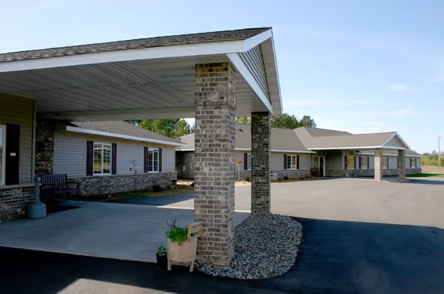 Exterior view of Carefree Living McGregor facility with covered driveways and brick pillars.