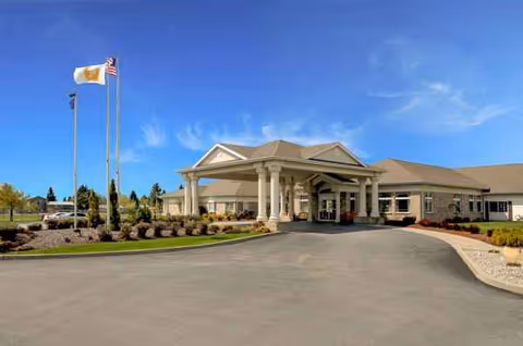 Front view of Life Care Center of Sandpoint with entrance canopy and flags.