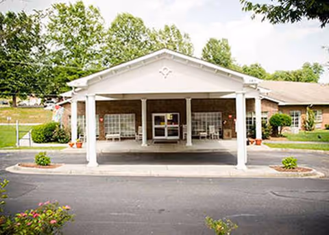 Front entrance of a senior living facility with a covered drop off area.