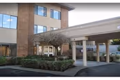 Exterior view of a Washington Care Center building with a covered entrance and landscaped shrubs.