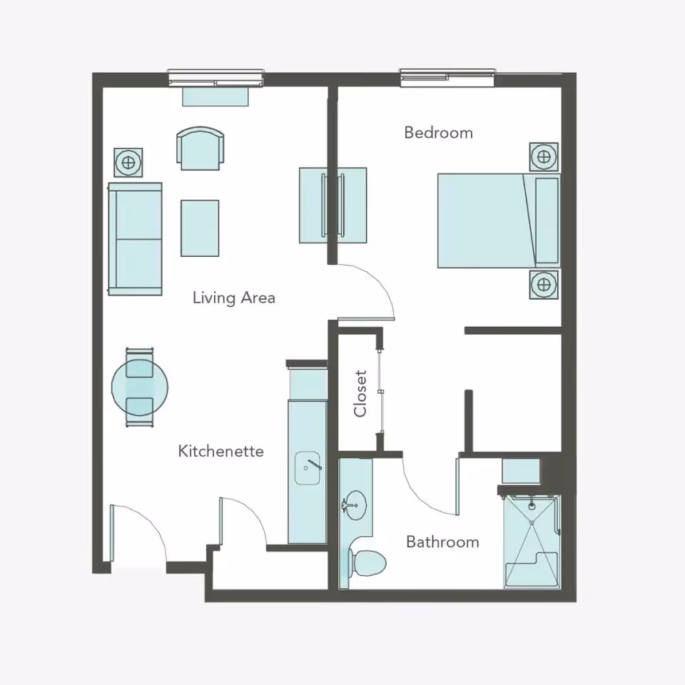 Floor plan of a senior living unit at Aegis Gardens Newcastle showing a living area with sofa, chair, and coffee table, a kitchenette with a small dining table and two chairs, a bedroom with a bed and two nightstands, a closet, and a bathroom with a toilet, sink, and shower.