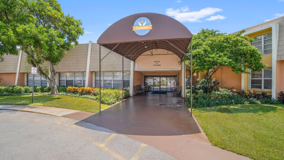 Front entrance of Cresthaven Senior Living Community with a covered walkway and landscaping.