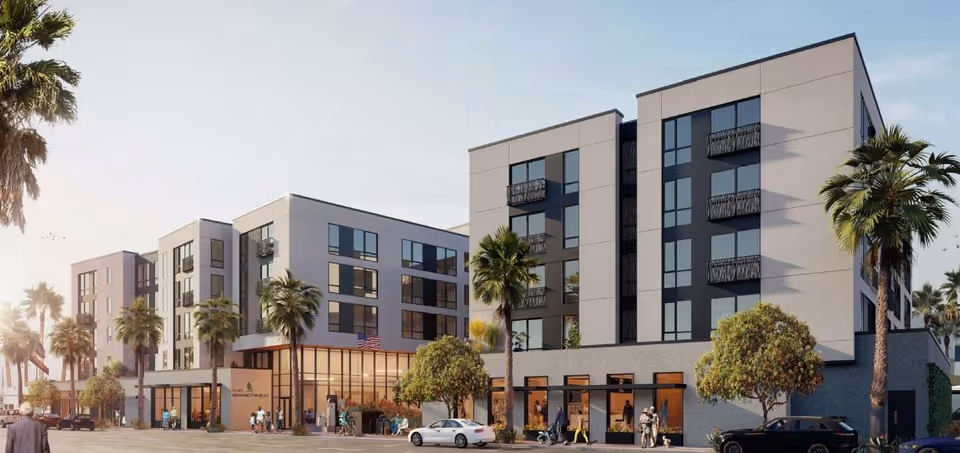 Modern four- to five-story senior living building with balconies, palm trees, ground-floor shops, cars and people in front.