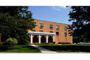 Brick exterior of Markley Rehabilitation & Healthcare Center with arched entrance and trees.