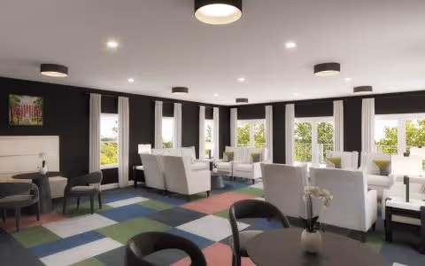 Bright communal lounge with white armchairs, round tables, and large windows overlooking greenery.