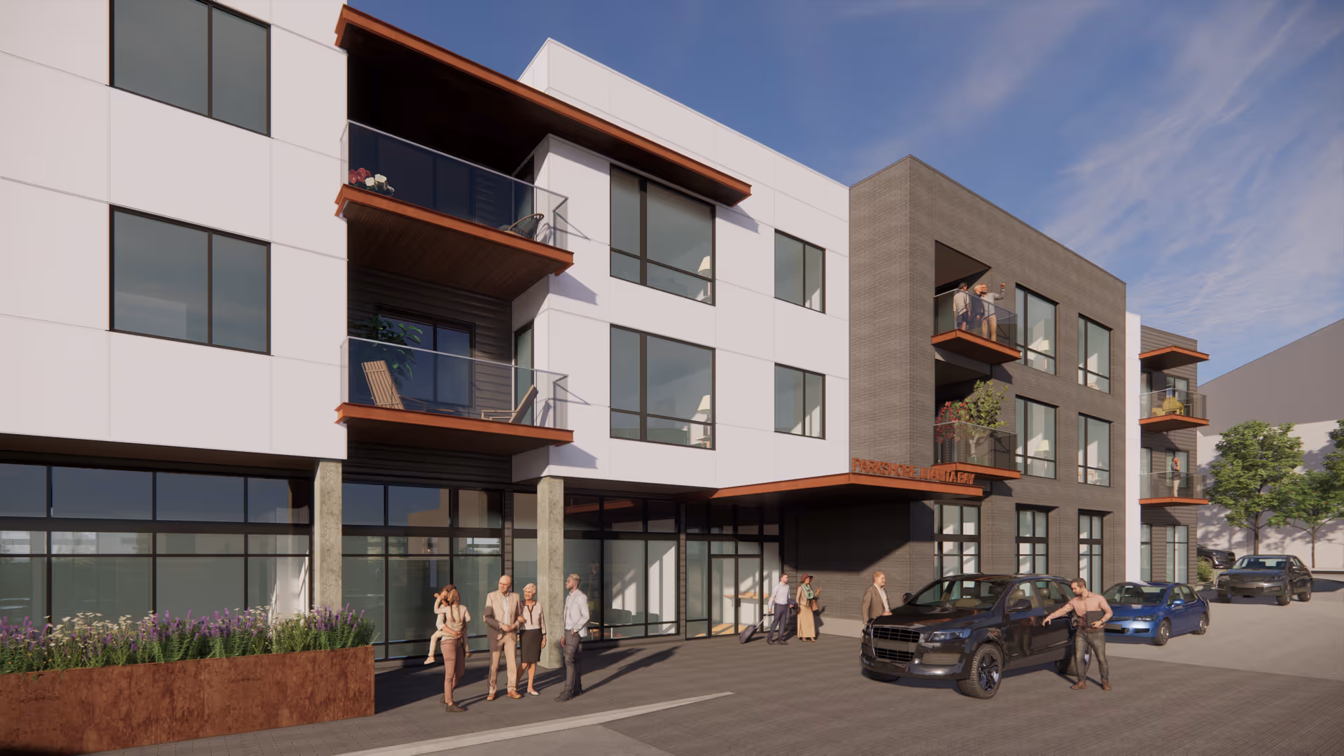 Front exterior of a modern three-story senior living building with balconies, an entrance canopy, parked cars, and people gathered outside.