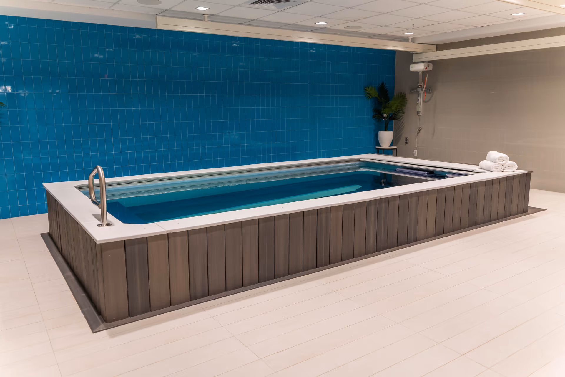 Indoor pool area with blue tiled wall and towels at LIVIA.