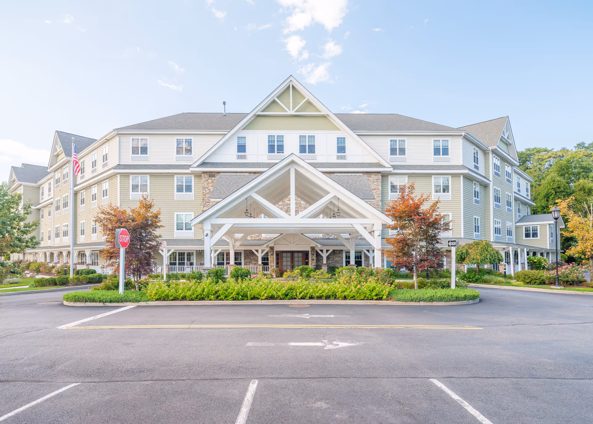 Front exterior view of Brightview Tarrytown - Senior Assisted Living & Memory Care building with a covered entrance, multiple windows, landscaped greenery, and a parking area in front.