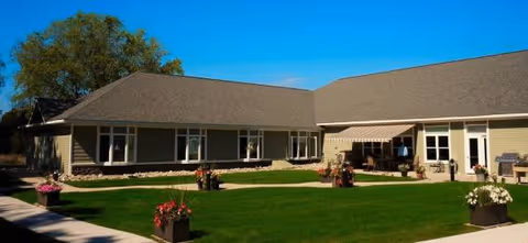 Mallard Cove Assisted Living exterior: single-story building with green lawn and patio.