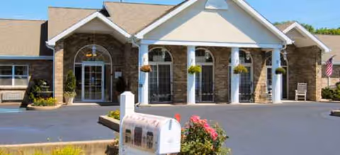 Exterior view of Brookdale Bloomsburg entrance with arched windows and columns.
