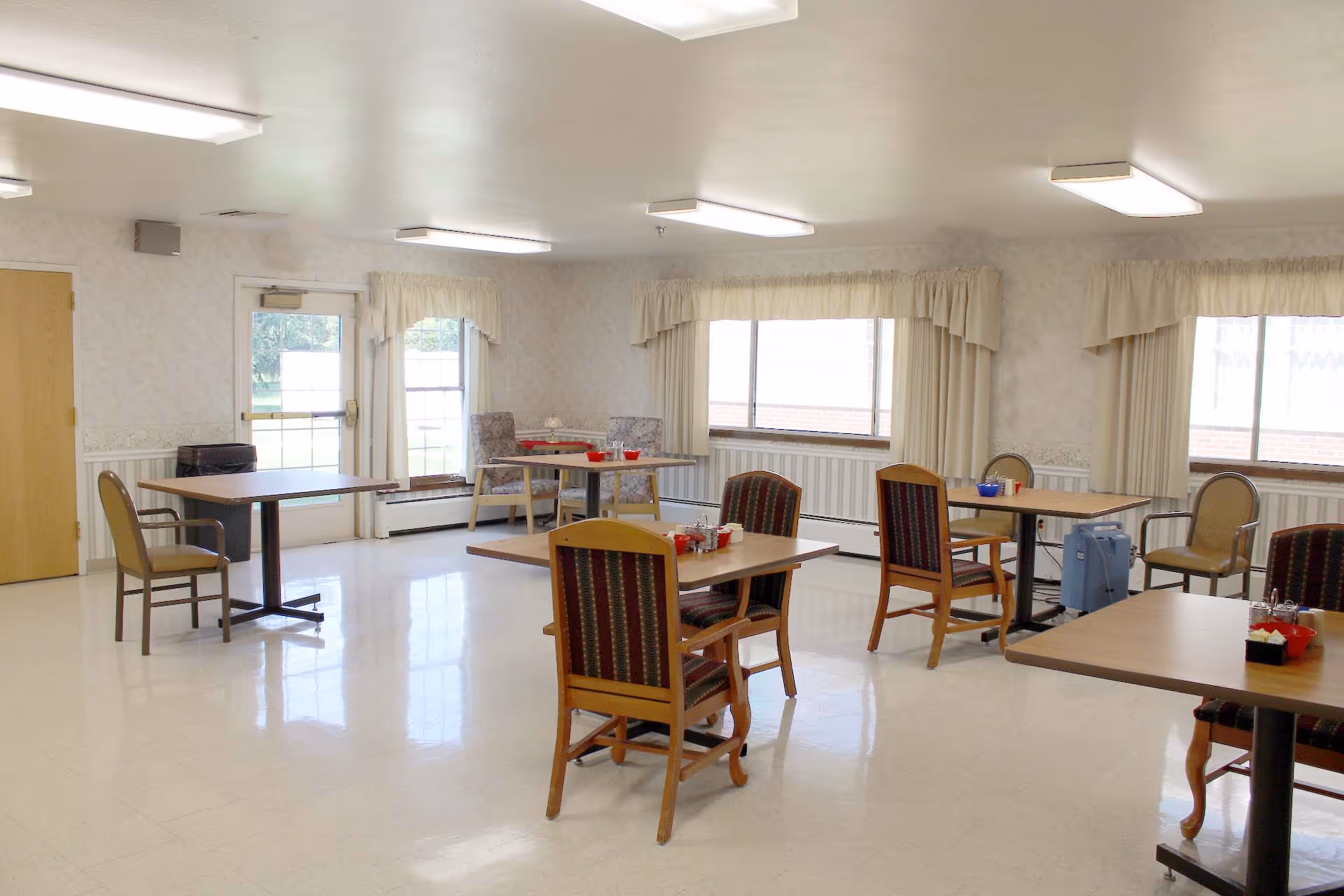 A spacious dining room with several tables and chairs at Accura HealthCare of Cascade.