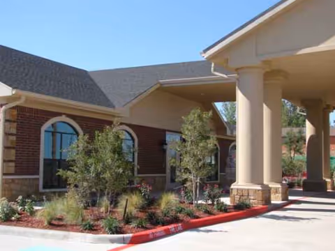 Exterior view of Amarillo Center for Skilled Care, featuring brick walls, arched windows, and columns.