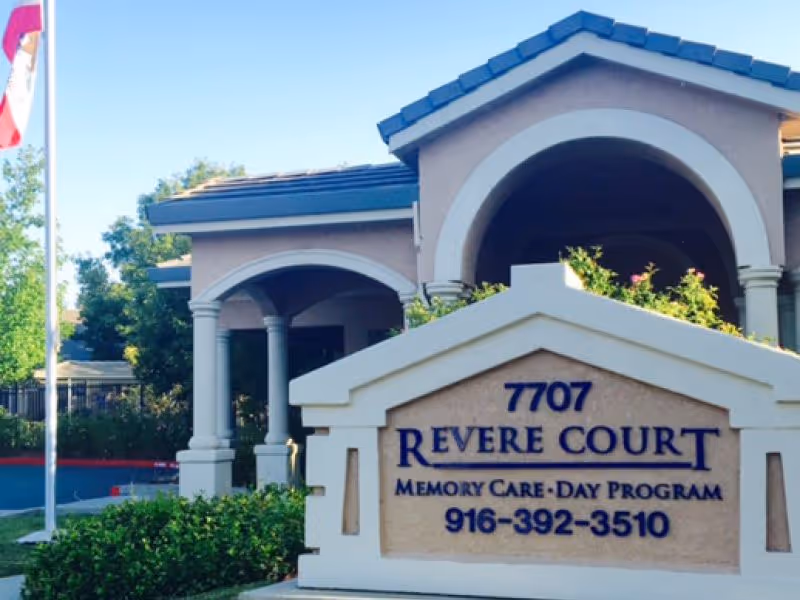 Entrance sign for Revere Court Memory Care in front of the facility's arched entryway.