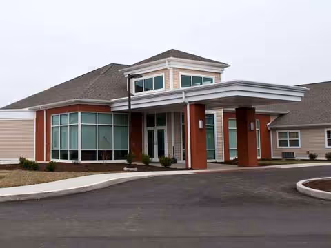 Exterior view of BridgePort Healthcare Center entrance with a curved driveway and glass windows.