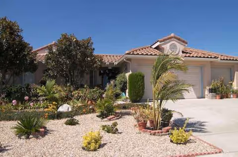 Front exterior of a Paradise Home Care facility with desert landscaping and a two-car garage.