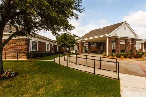 Exterior of The Villa at Mountain View showing brick building, covered entrance, and accessible ramp.