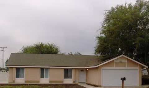 Front view of Walnut Senior Home, a single-story beige building with a garage.