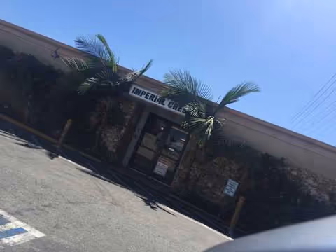 Exterior view of Imperial Crest Healthcare Center entrance with palm trees and parking lot.