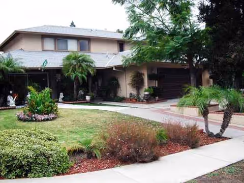 Front view of Golden Years senior living facility with curved driveway and landscaped yard.