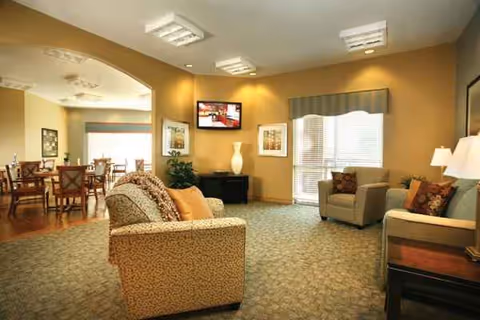 Interior common lounge at Meadowbrook Rehabilitation Hospital with seating, TV, and dining area.