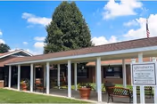 Glenburn Home exterior with a covered porch, benches, and sign.