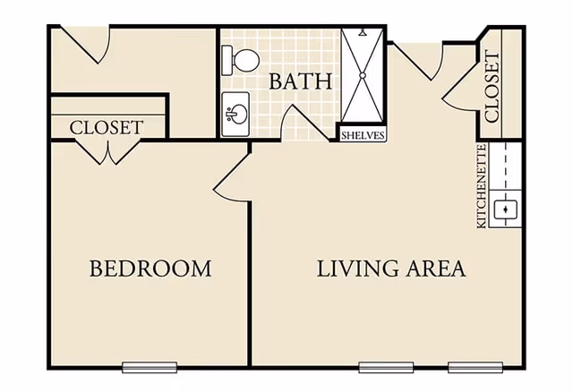 Floor plan of a one-bedroom apartment at Heritage Place of Boerne, showing a bedroom with a closet, a bathroom with a shower, toilet, sink and shelves, a living area with a kitchenette and a closet.