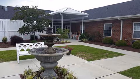 Outdoor courtyard at The Indigo at Pikeville with a fountain, benches, and a covered seating area.