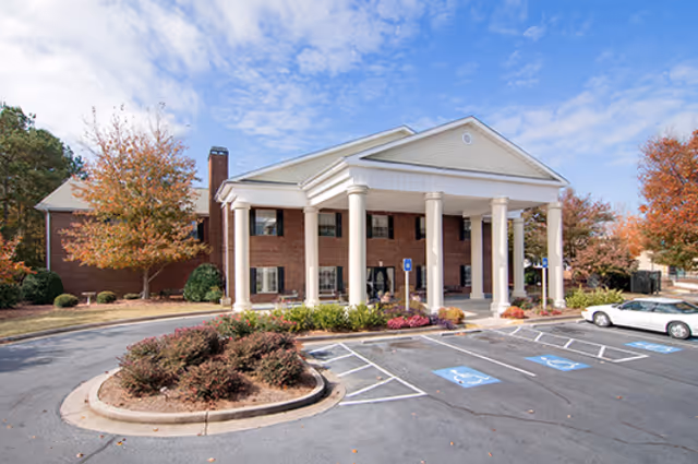 Heritage of Marietta front entrance with columns, brick facade, and accessible parking.