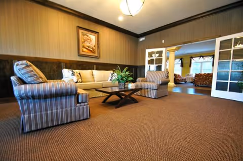 Lobby lounge at Mallard Cove Assisted Living with striped chairs and a coffee table.