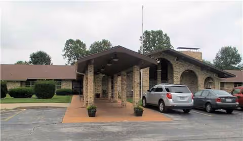 Exterior view of Brookhaven Nursing & Rehab with a covered entrance and parked cars.