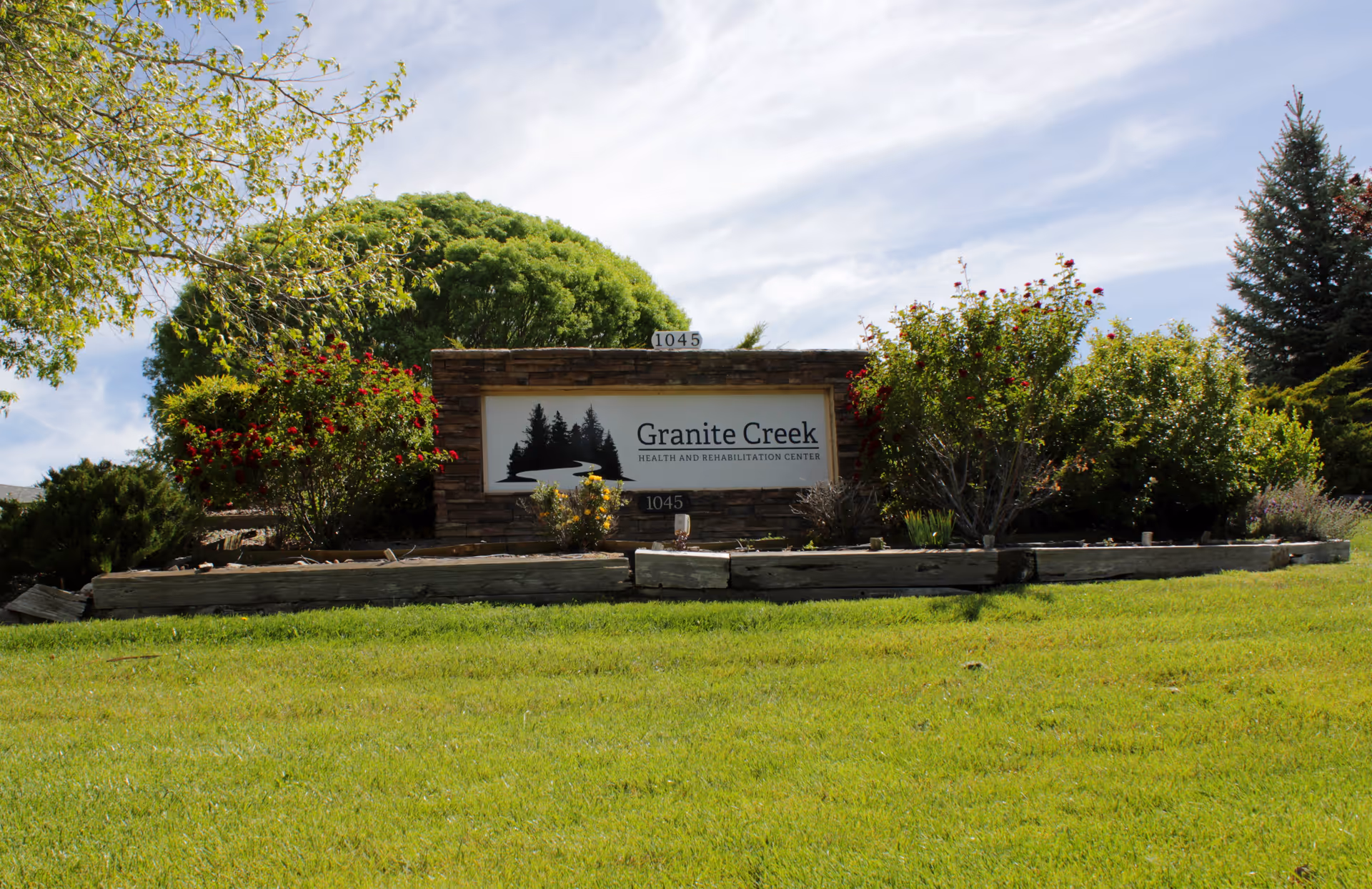 Stone entrance sign reading 'Granite Creek Health and Rehabilitation Center' surrounded by shrubs and a grassy lawn.