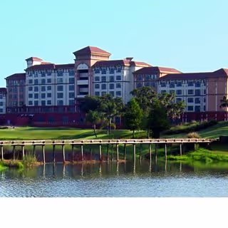 Front view of a large Freedom Pointe senior living building beside a pond.