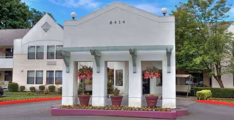 Exterior view of Solstice Senior Living at Point Defiance front entrance with potted plants.