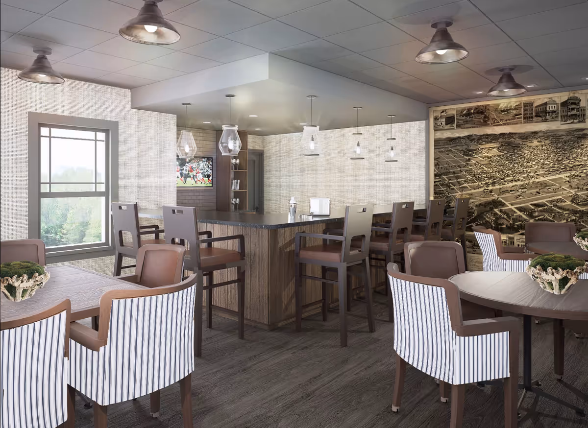 Communal dining/lounge area with round tables, upholstered chairs, a central bar with high stools, pendant lighting, and a large mural on the wall.