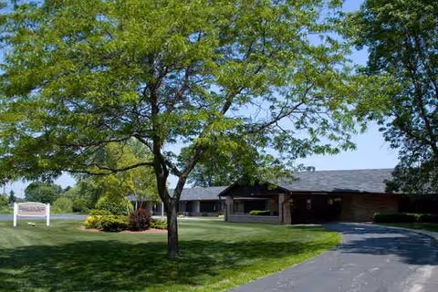 Exterior view of a Meadow View Health Services building with trees and a curved driveway.