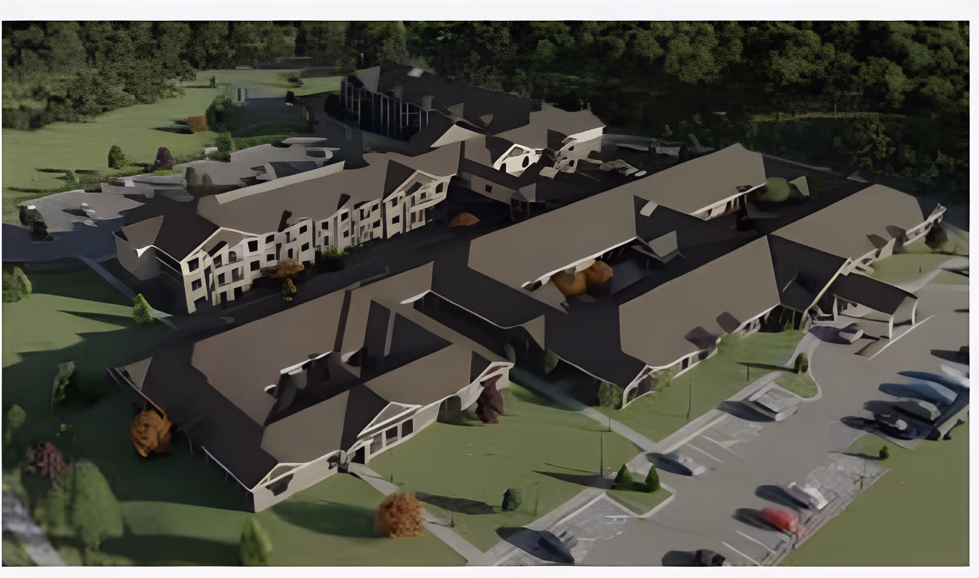 Aerial rendered view of a multi-building retirement community complex with parking areas and surrounding trees.